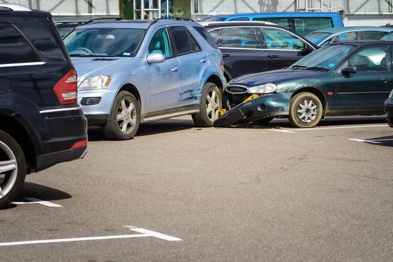 Zderzenie samochodów na parkingu. Nieostrożne parkowanie zbyt blisko drugiego samochodu doprowadziło do uszkodzenia zderzaka.