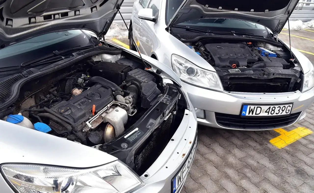 Dwa silniki samochodowe z otwartymi maskami. Jeden to diesel, drugi benzyna. R&oacute;żnice widać w budowie.