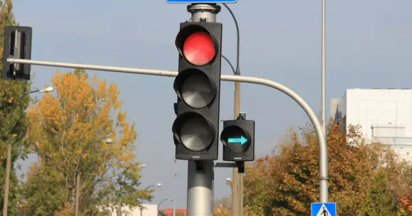 Sygnalizacja świetlna z czerwonym światłem i zielona strzałka wskazująca skręt w prawo.