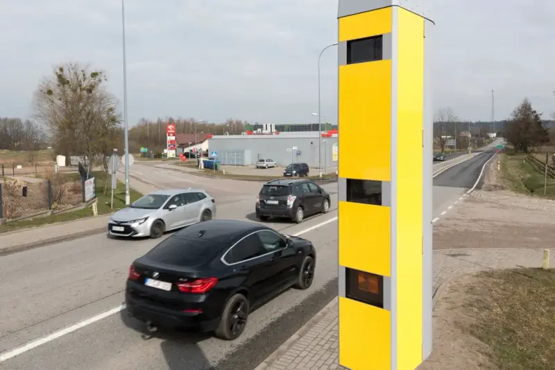 Żółty fotoradar przy drodze, monitorujący ruch samochodów. Tak działa system, który rejestruje prędkość pojazdów.